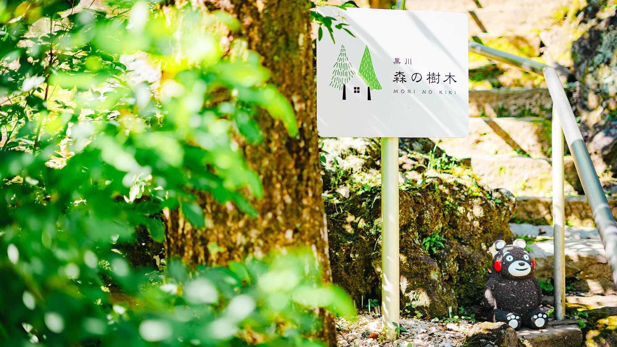【森の樹木】建物の目印として、近くに看板を設置しています。くまモンもお出迎え！
