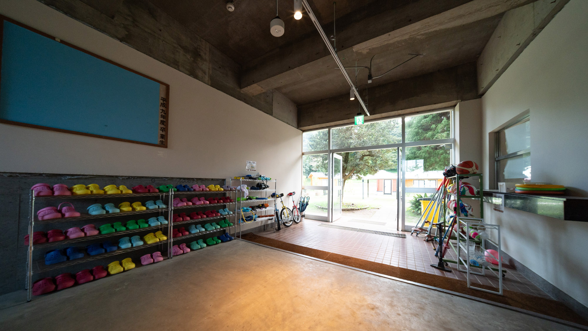 カラフルなサンダルと遊具が並ぶ玄関スペース。雨の日も晴れの日も、童心に返って楽しめる。