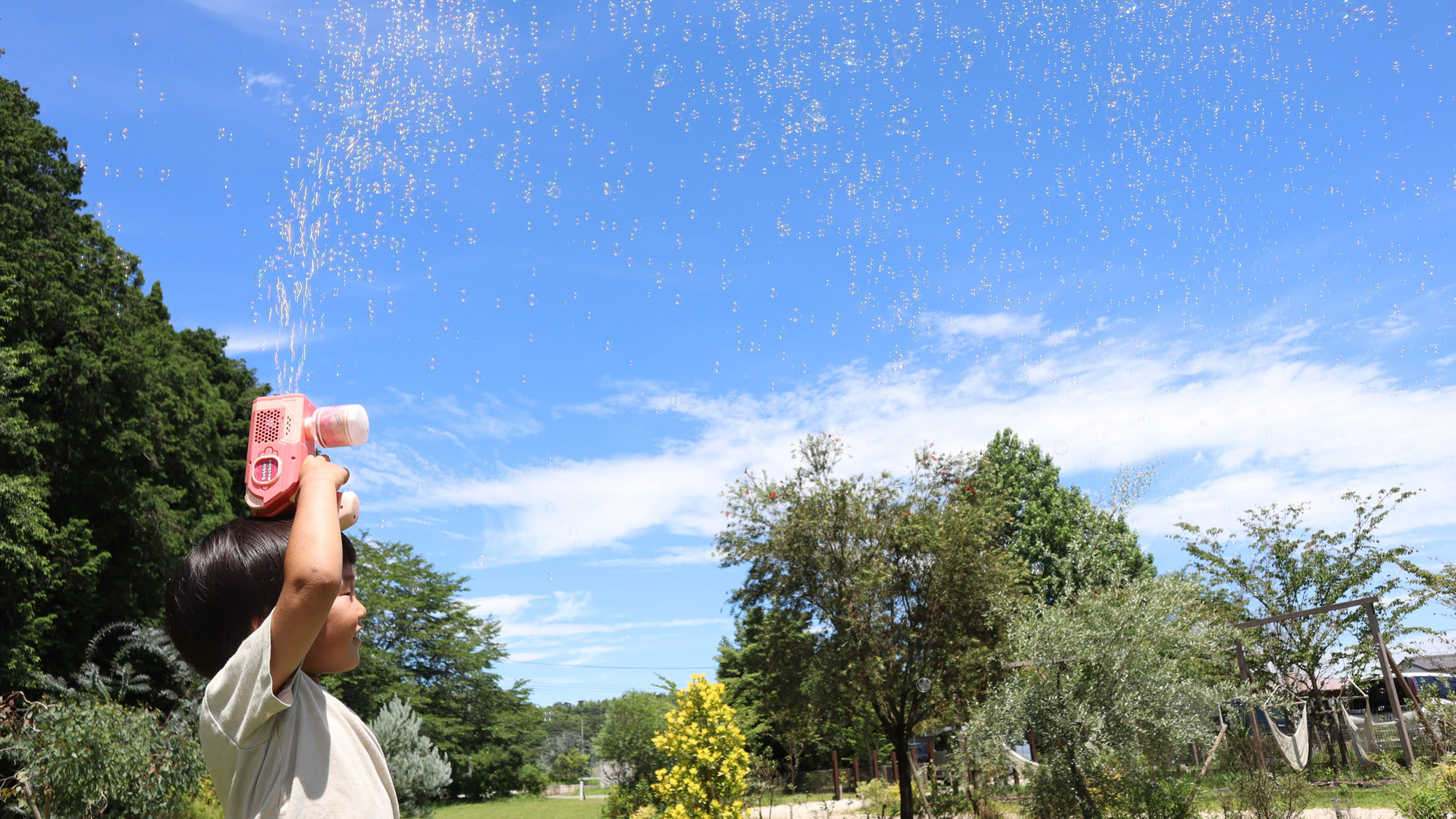 青空の下、シャボン玉遊びで笑顔あふれる夏のひととき。