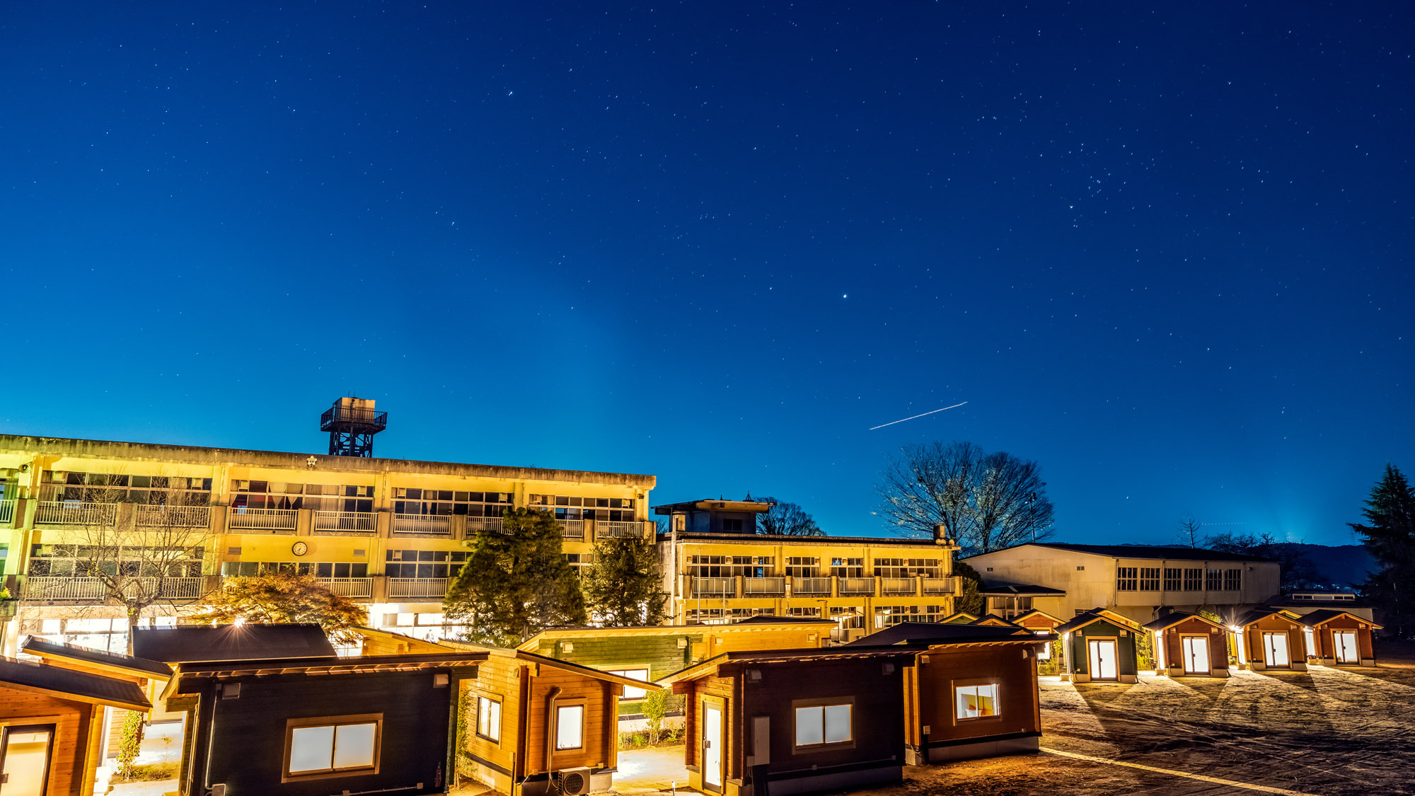 星空の下、灯りがともるキャビンと校舎。静けさとあたたかさが心を満たします。