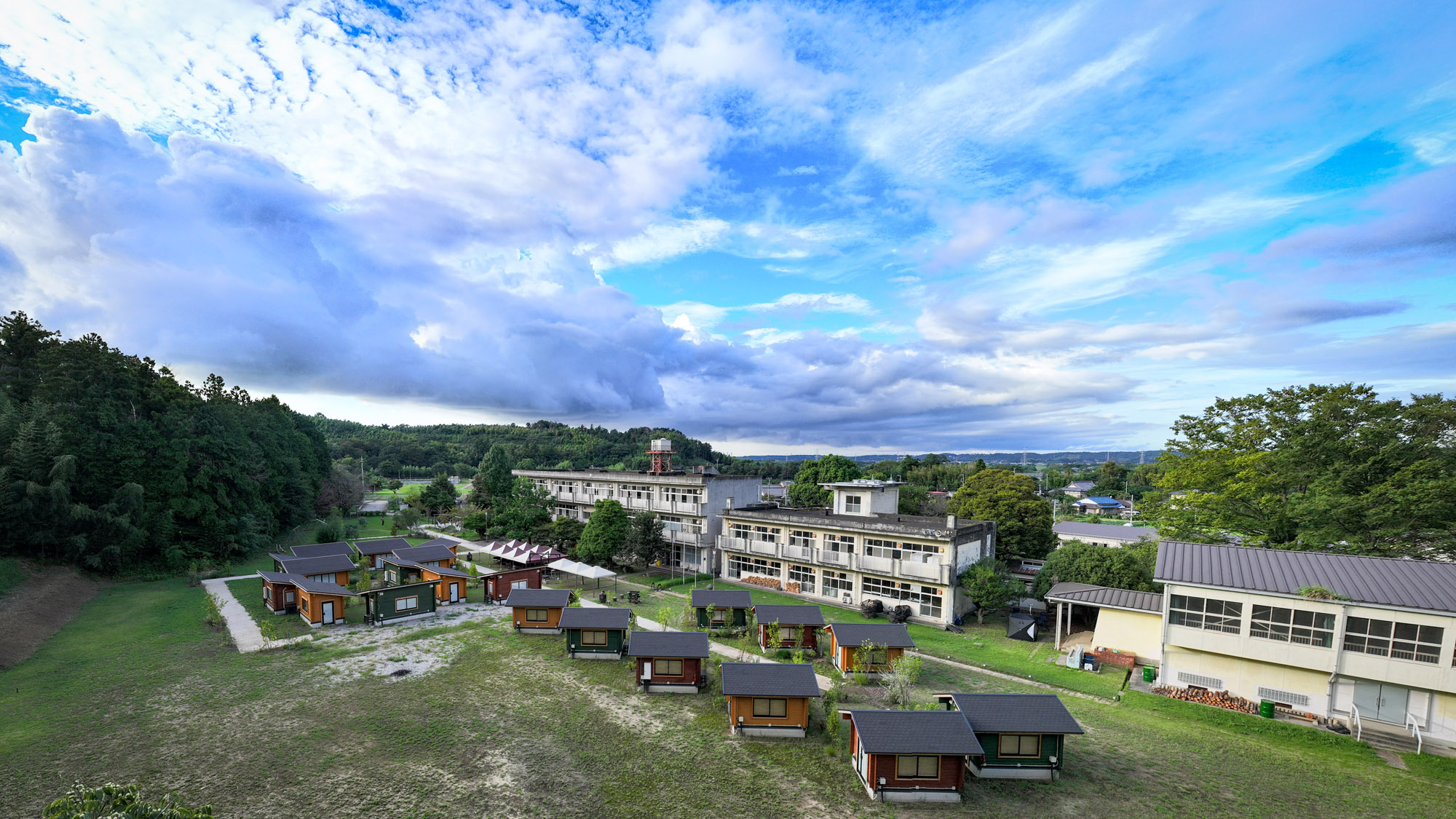 自然に囲まれた旧校舎とキャビンが並ぶ、ETOWA木更津の全景。