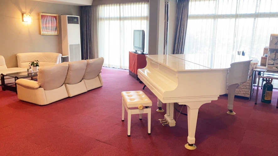 ・【ロビーエントランス】白いグランドピアノとソファーがラグジュアリーな雰囲気