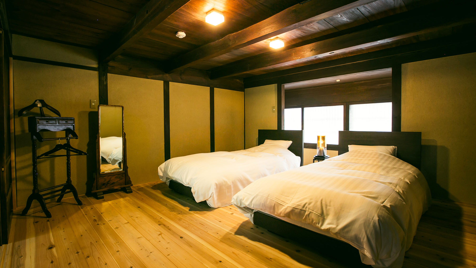 ・【ベッドルーム】ツインベッドをご用意。温かみのある空間で心身ともにゆったりお寛ぎください