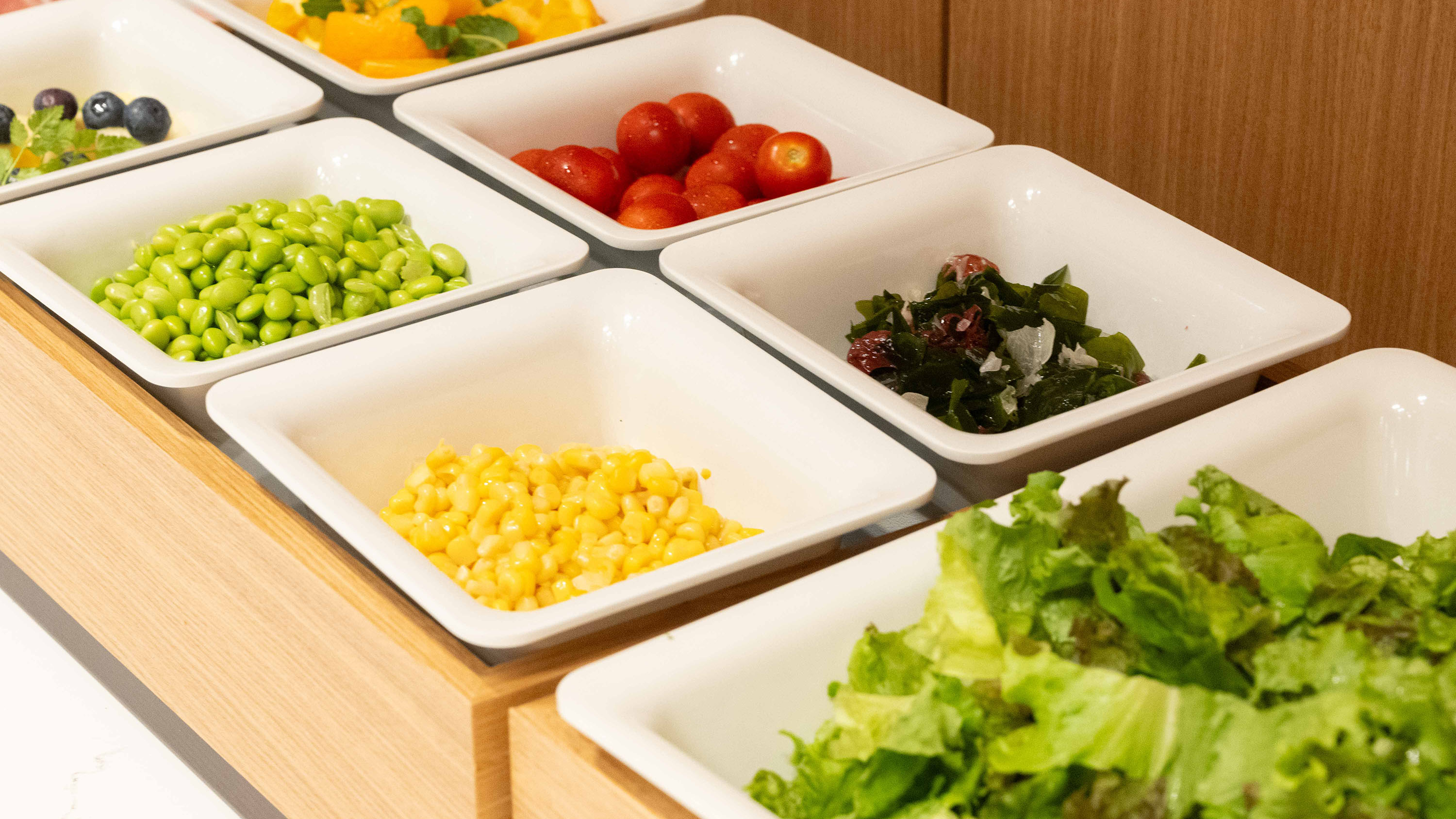 朝食ビュッフェ｜彩り豊かな野菜やフルーツが並ぶ、華やかなサラダコーナー。