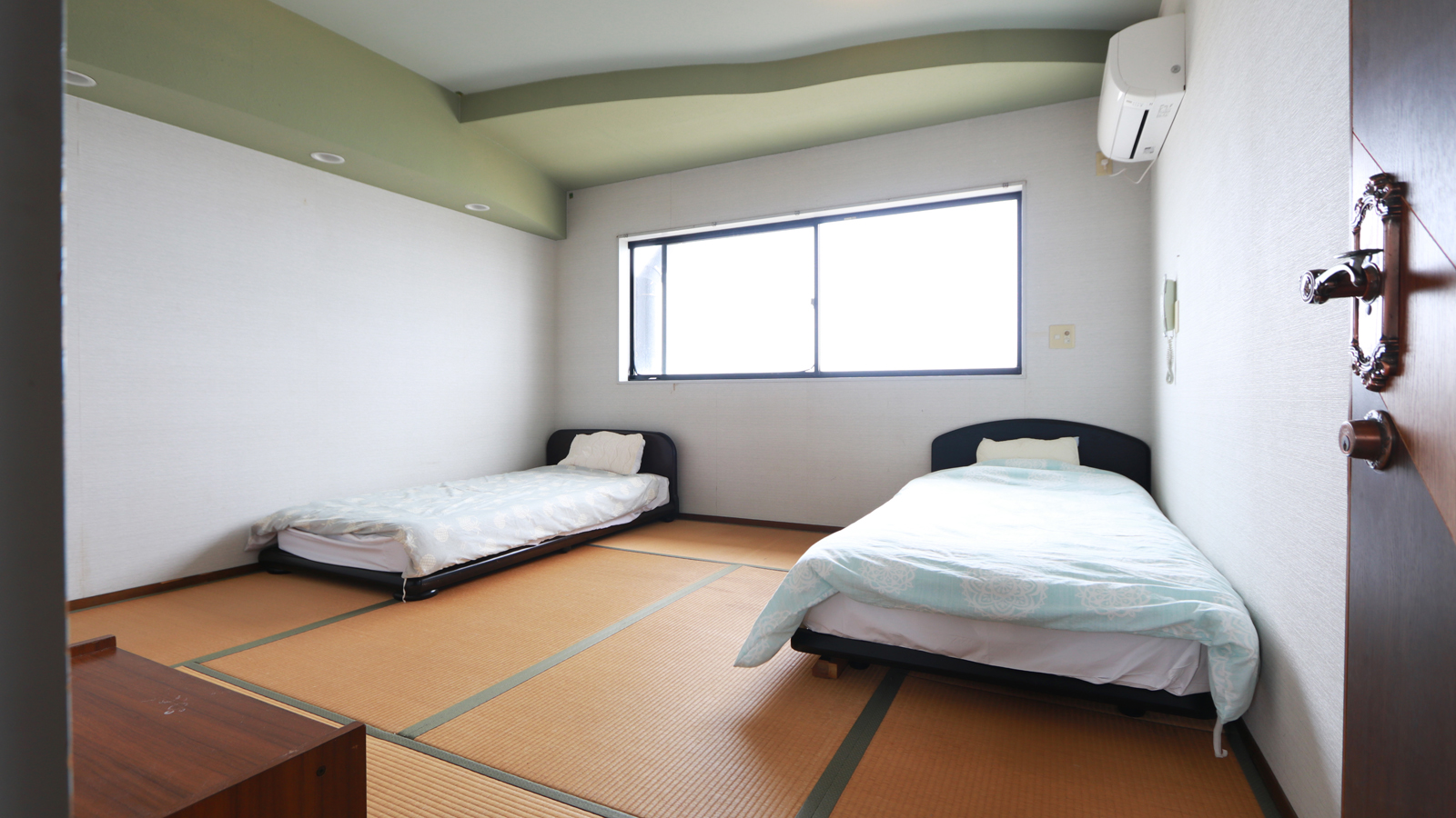 【和室　E】-和室ツイン- 畳の上にシングルベッドを二台設置。靴を脱いで、のんびりお過ごしください。