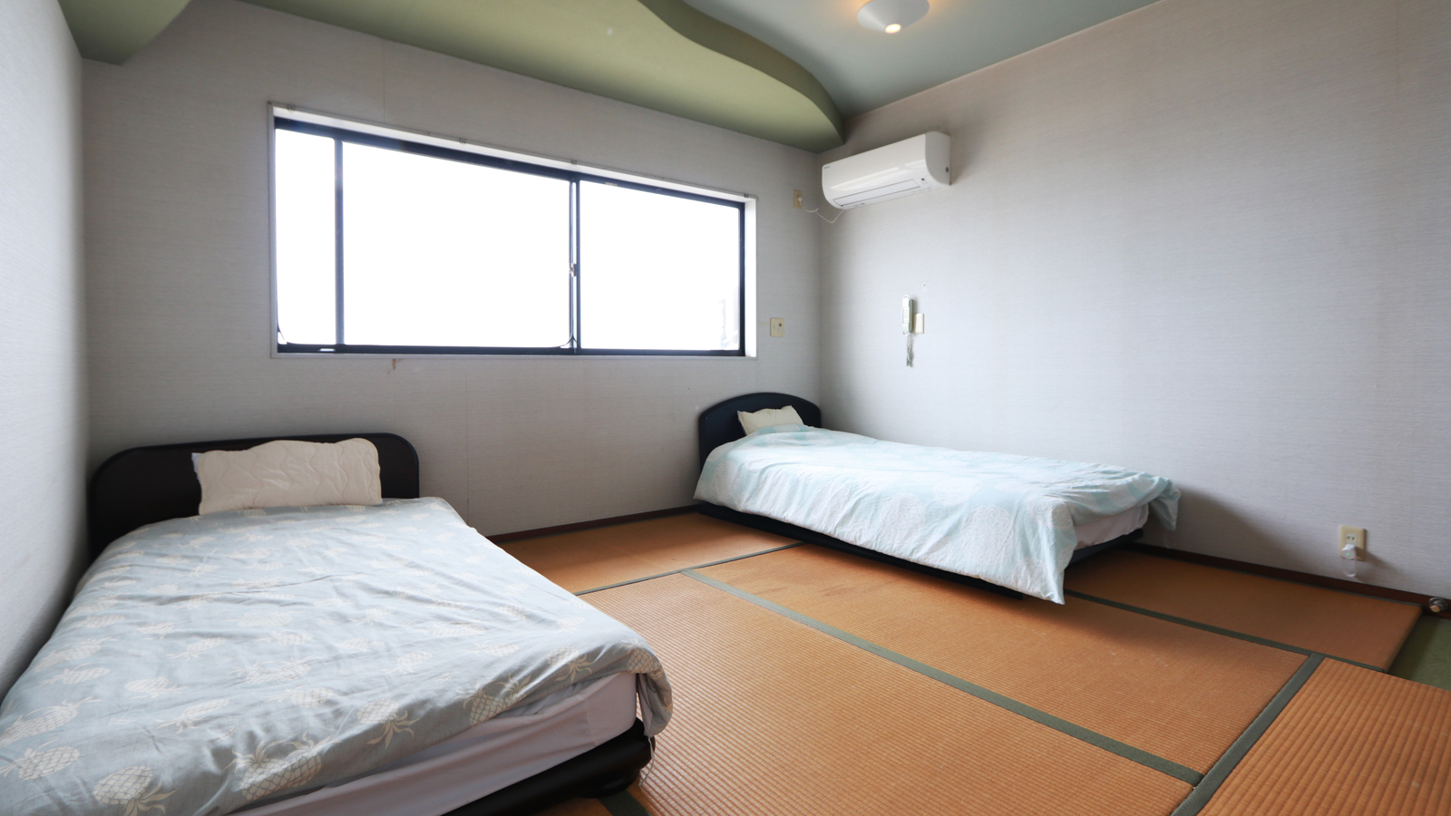【和室　E】-和室ツイン- 畳の上にシングルベッドを二台設置。靴を脱いで、のんびりお過ごしください。