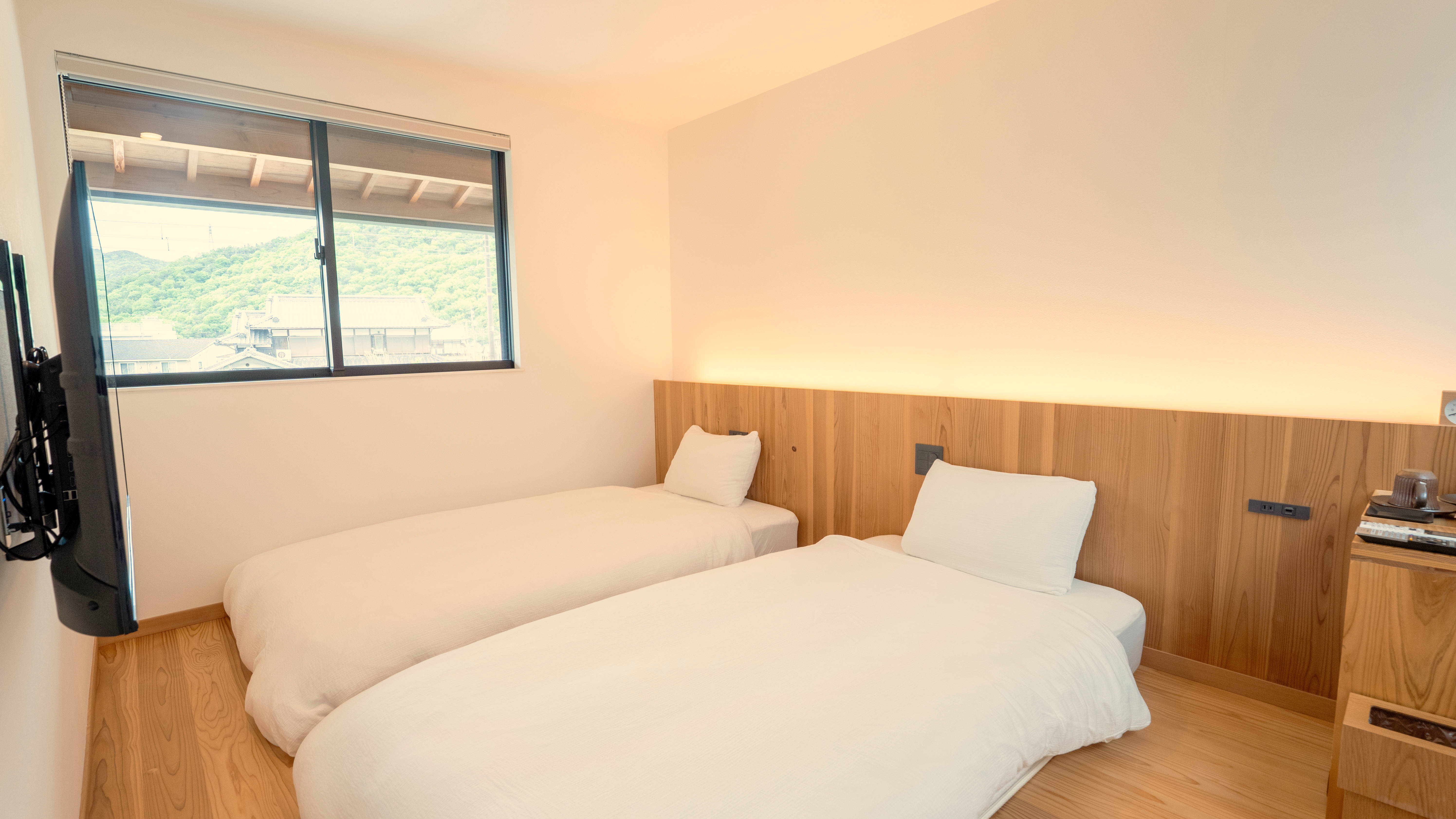 シングルツイン【レトロビュー】：お部屋から電車を眺めることができる、シングルベッド2台のお部屋です。