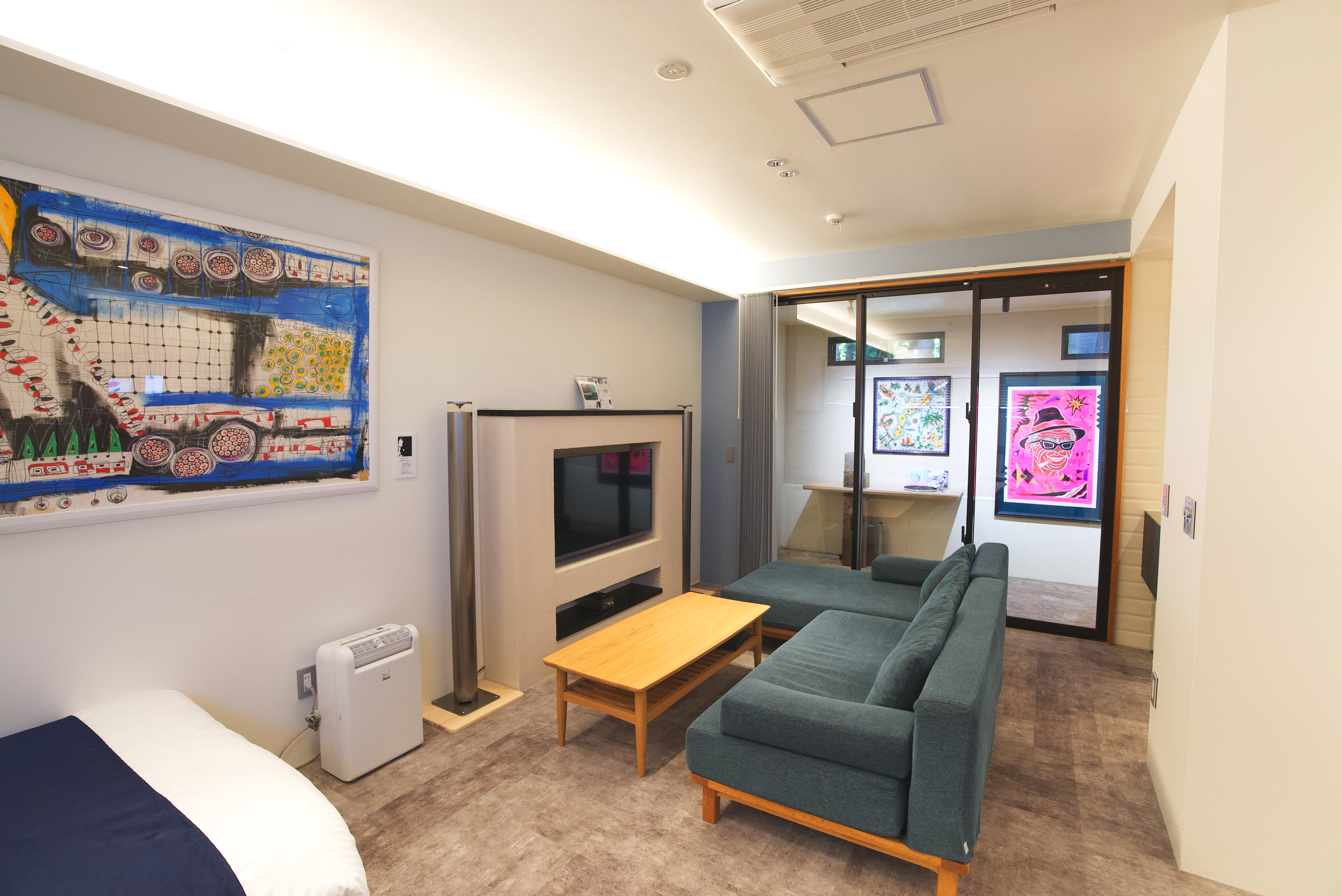 【E棟】リビング。モダンアートや美術品に囲まれたお部屋になっております。