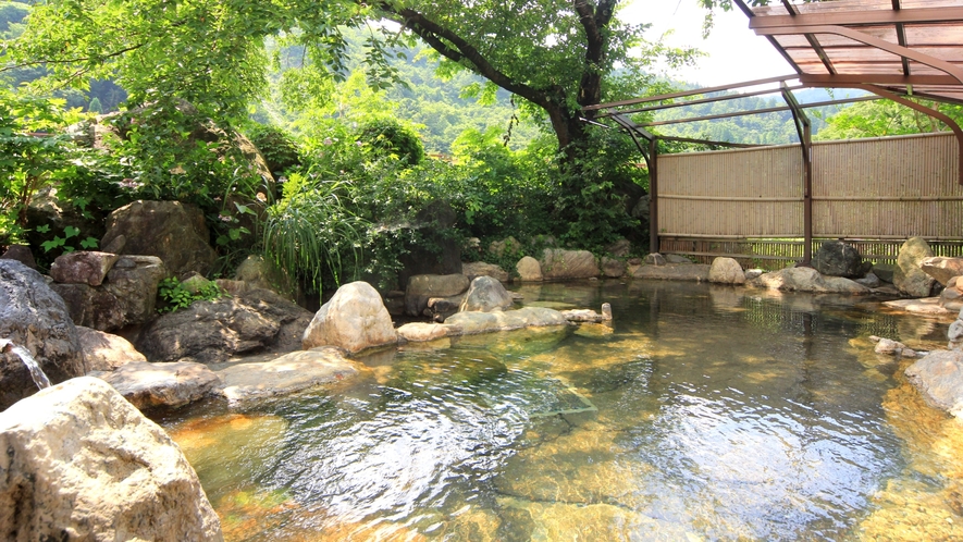 【温泉】露天風呂。樹々に囲まれ、絶え間なく注がれるかけ流し姫川温泉をゆったりと楽しめます。