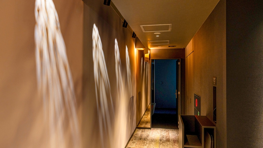 【館内デザイン（廊下）】照明の光を壁にあて隠し絵のような楽しみ方が出来るデザインです。