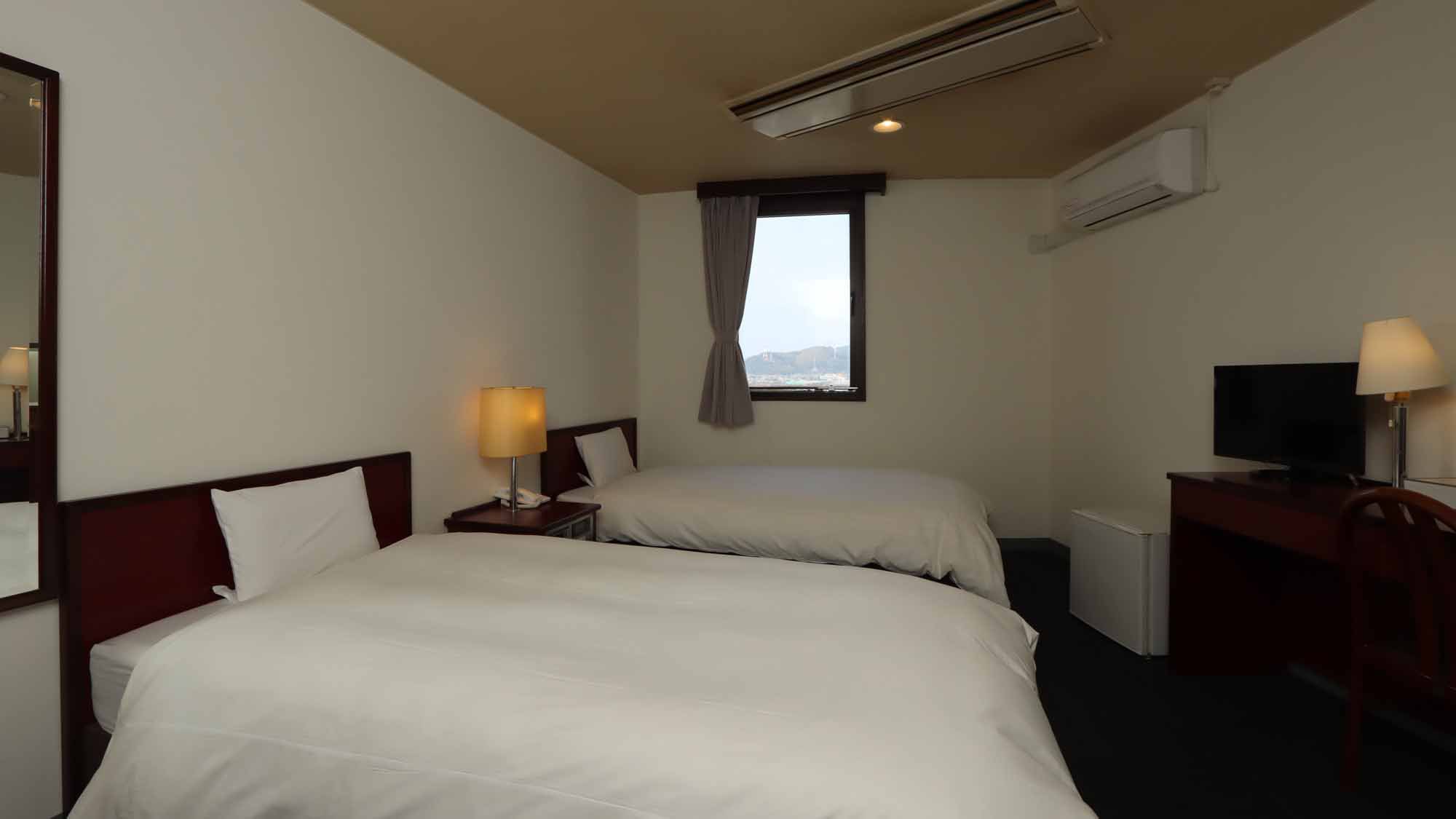 【ツイン】15㎡のリビングスペースにシングルベッドを２台備えた客室です