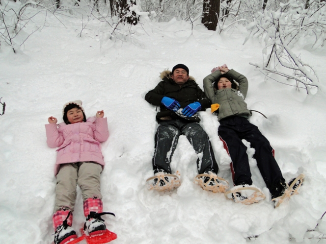 ふかふかの雪に寝転ぶ親子