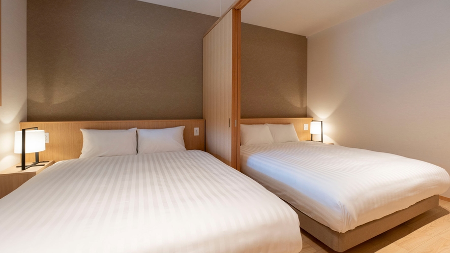 【102・103】寝室／間仕切りにより、多様な滞在スタイルに対応できるクイーンベッドの寝室
