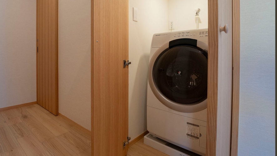 【離れ】廊下の押し扉の奥に乾燥機能付き洗濯機がございます。