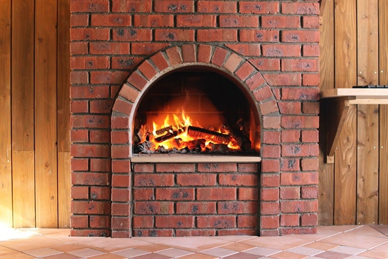 煉瓦のアーチがチャームポイントの焚火暖炉。 火を熾すと、バチバチ音を立てて燃え上がります。