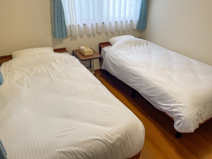 こちらの寝室にはシングルベッドが2台配置されており、快適な個別の寝台が提供されています
