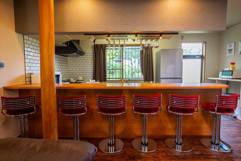 カウンターにオシャレな赤いチェアが6脚