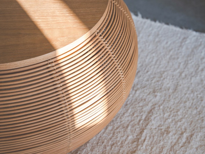 ・【ラウンジ】ラタンを繊細に編み込んだ円形ローテーブルがシンプルな空間に調和