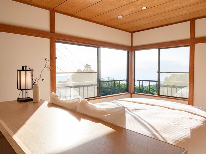 ・【洋室】クイーンサイズのベッドを設置。二方向の窓から光がさし込みます