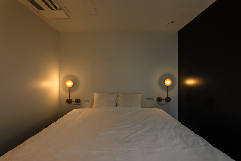 特注照明やスイッチのゴールド色を交えてリュクスな雰囲気を演出。照明はソフトなあたたかみのあるラ...