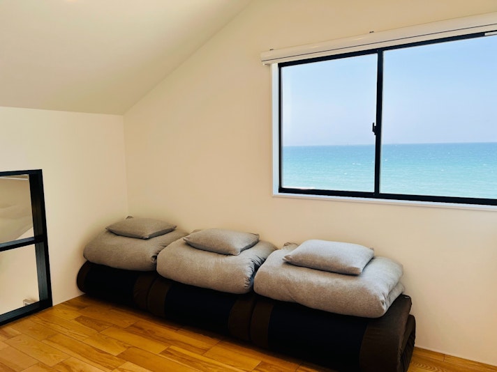 ２F洋室２，地平線が望める窓には、鮮やかな青色の海が広がります。