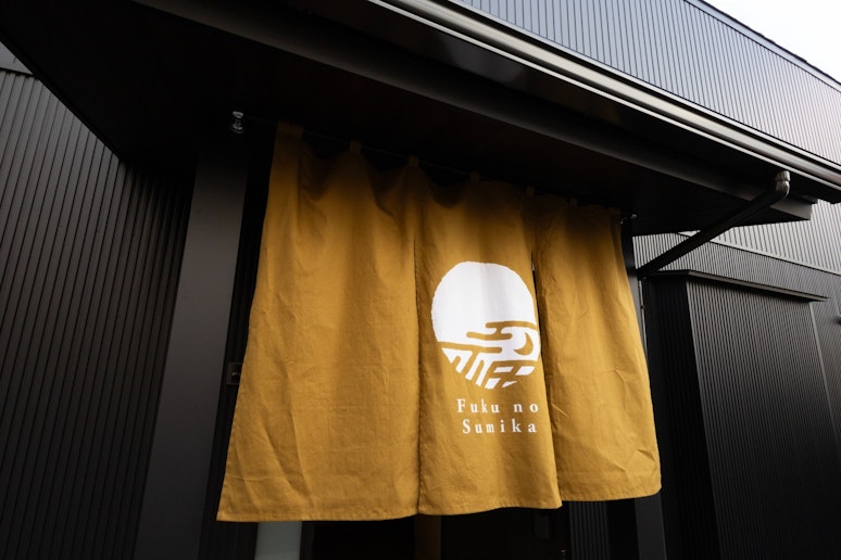 宿泊者用玄関は建物右側中央になります。駐車場も完備しています