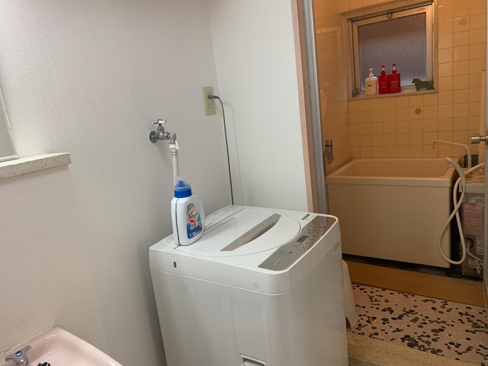 洗濯機と洗剤。奥がバスルームです。