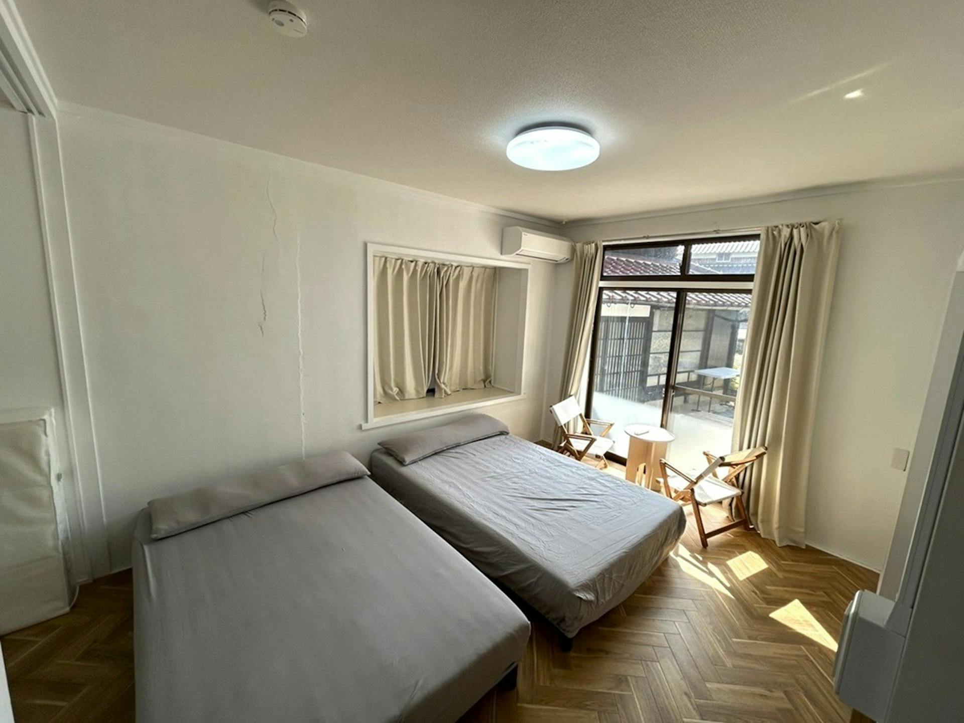 【居室B (7帖) 1階】セミダブルベッド×2、ローテーブル×1、チェア×2