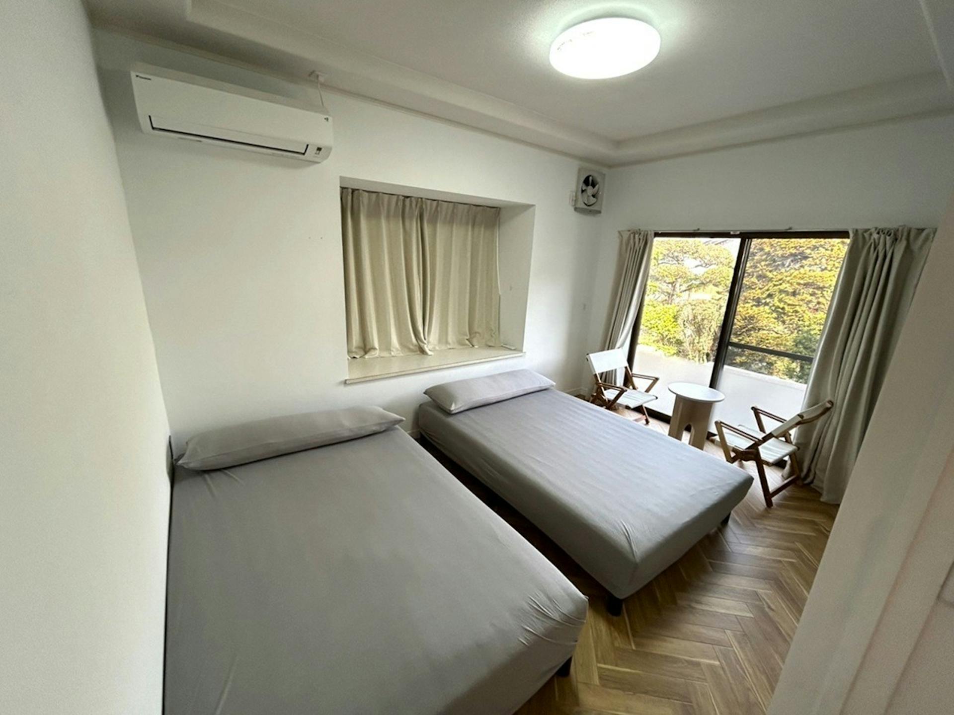 【居室A (7帖) 1階】セミダブルベッド×2、ローテーブル×1、チェア×2