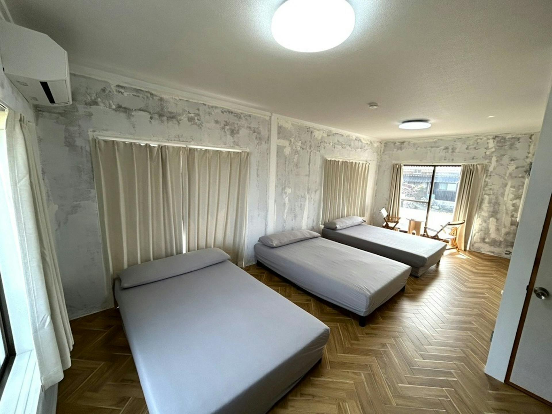 【居室C (15帖) 2階】セミダブルベッド×3、ローテーブル×1、チェア×2