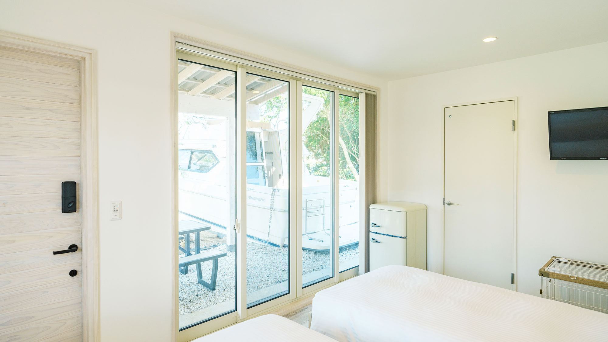 【クルーザーコテージA／39.48㎡】壁一面の大きな窓からは美しい海の風景を楽しめます。