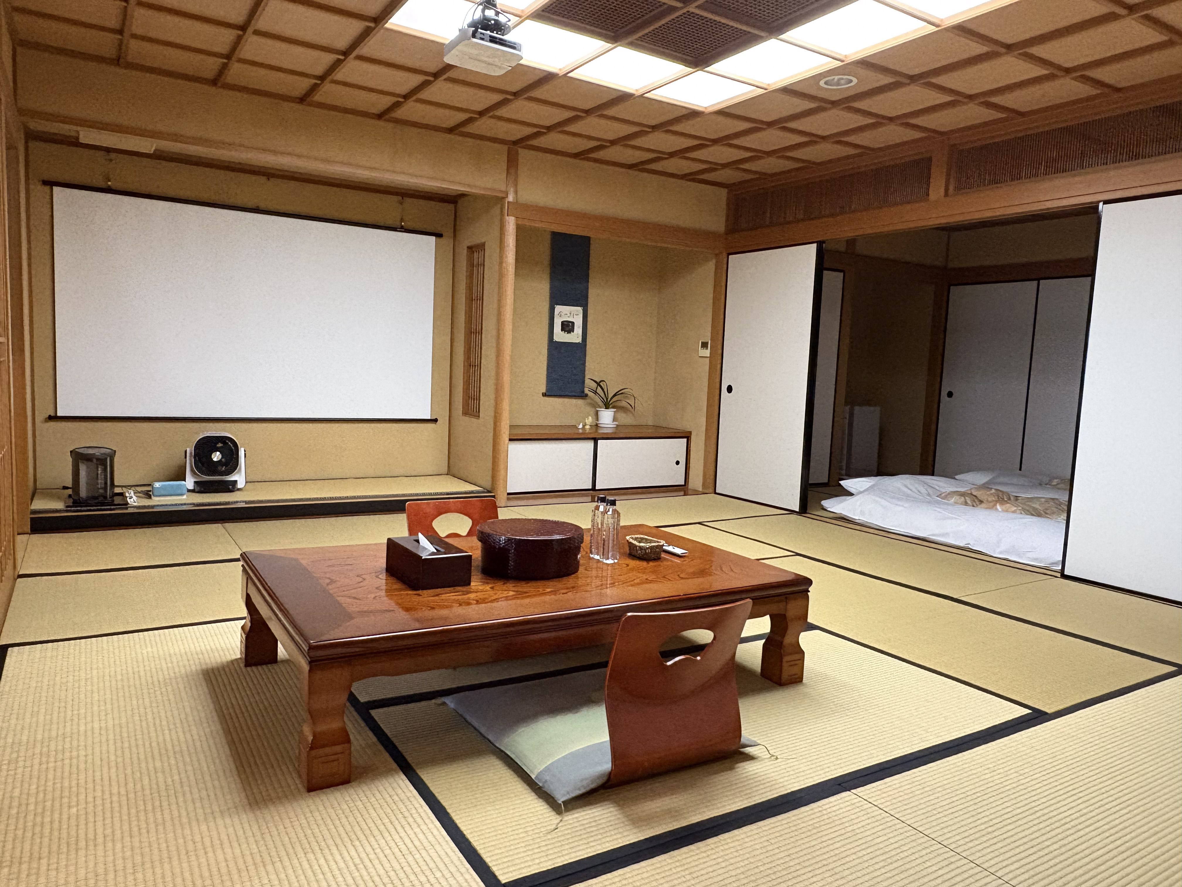 広々としたメインのお部屋は12.5畳！大型ホワイトスクリーンにプロジェクター完備で、インターネットを繋いでNETFLIXやyoutubeも楽しめます♪ また、研修などでご利用の場合にはホワイトボードもございますので、お部屋でミーティングもできます。学生グループも大歓迎！みんなでワイワイできる広さで、色々な使い方でご利用ください。