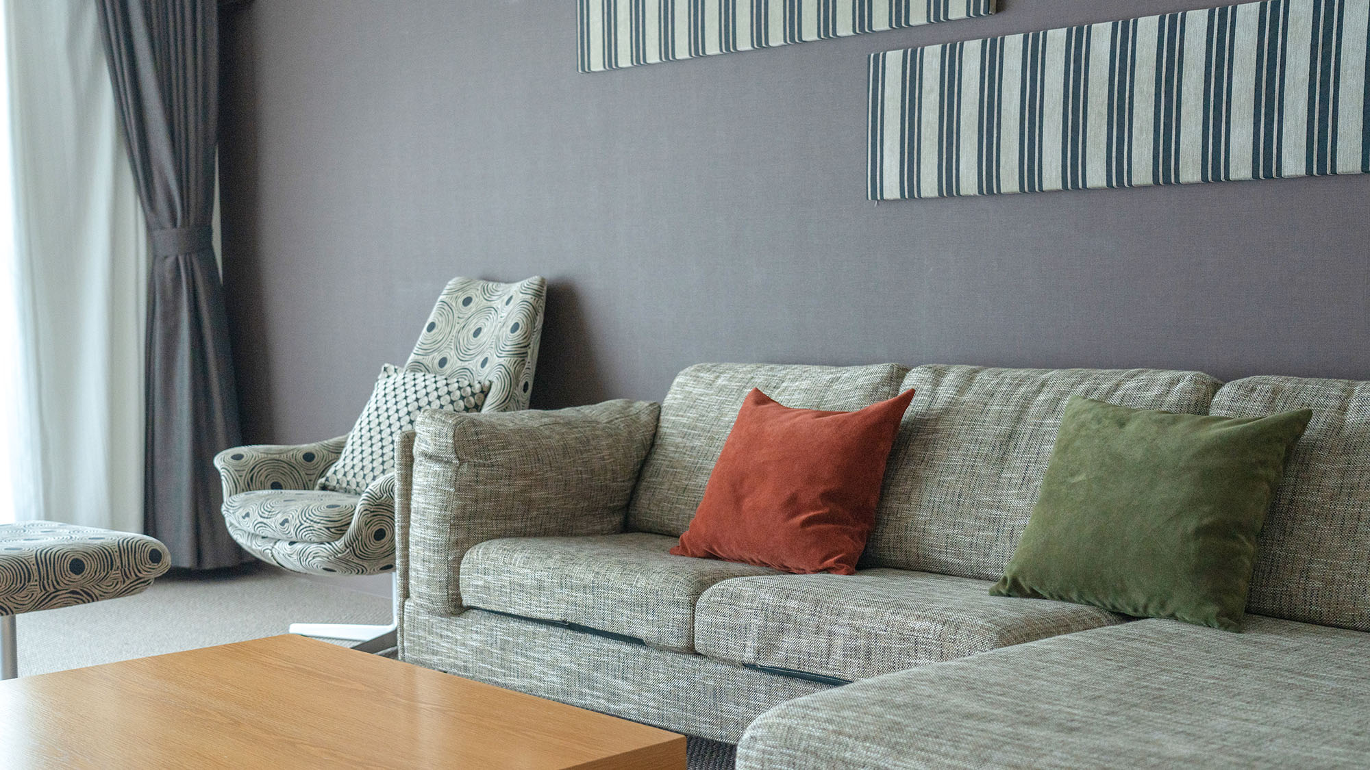 ・【DXスイート】L字ソファを設置しております。ゆったり腰掛けて寛ぎ時間をお過ごしください