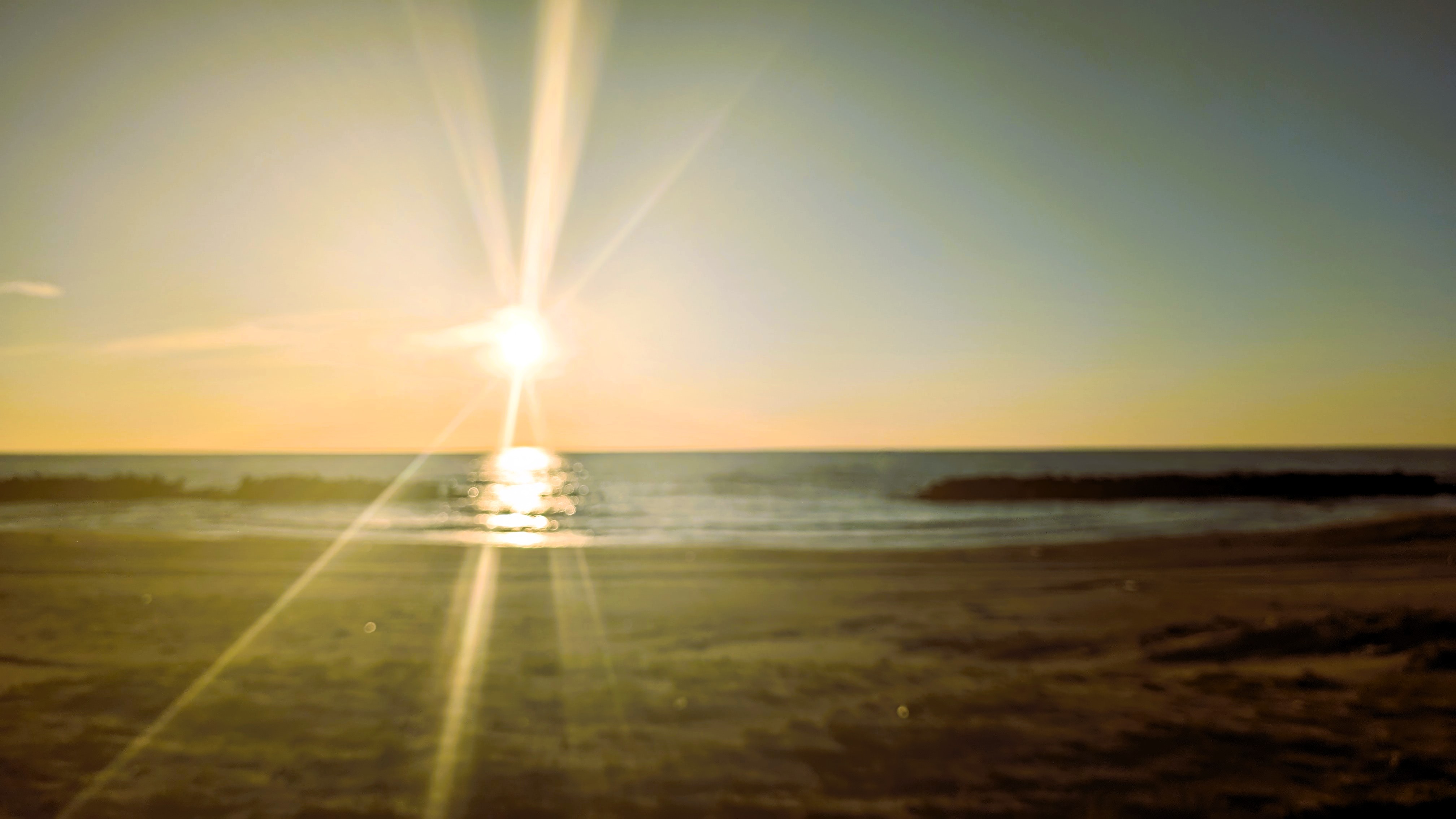 歩いて数十秒の砂浜。　夕日の空黄色　