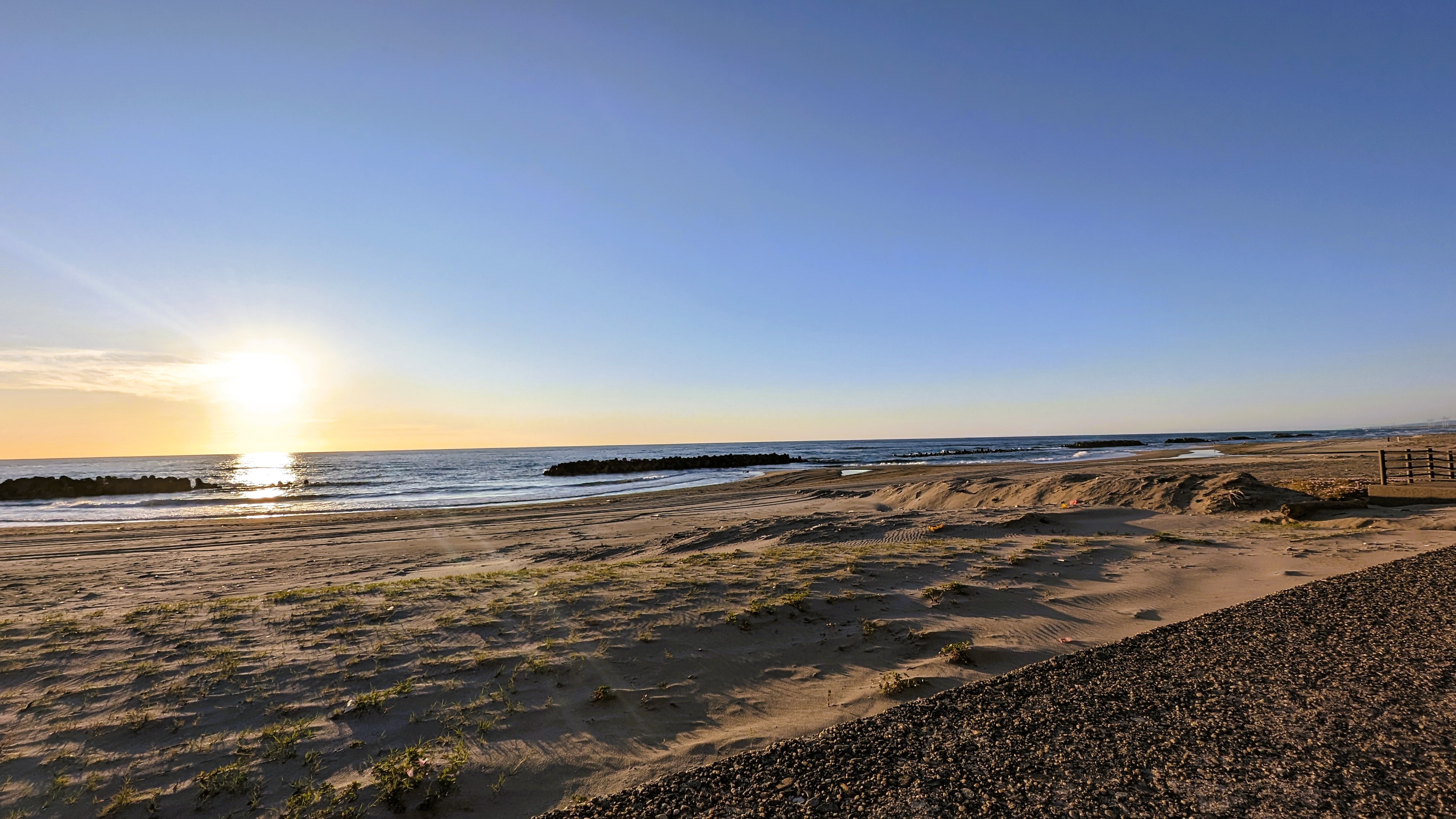 歩いて数十秒の砂浜。　夕日の空青