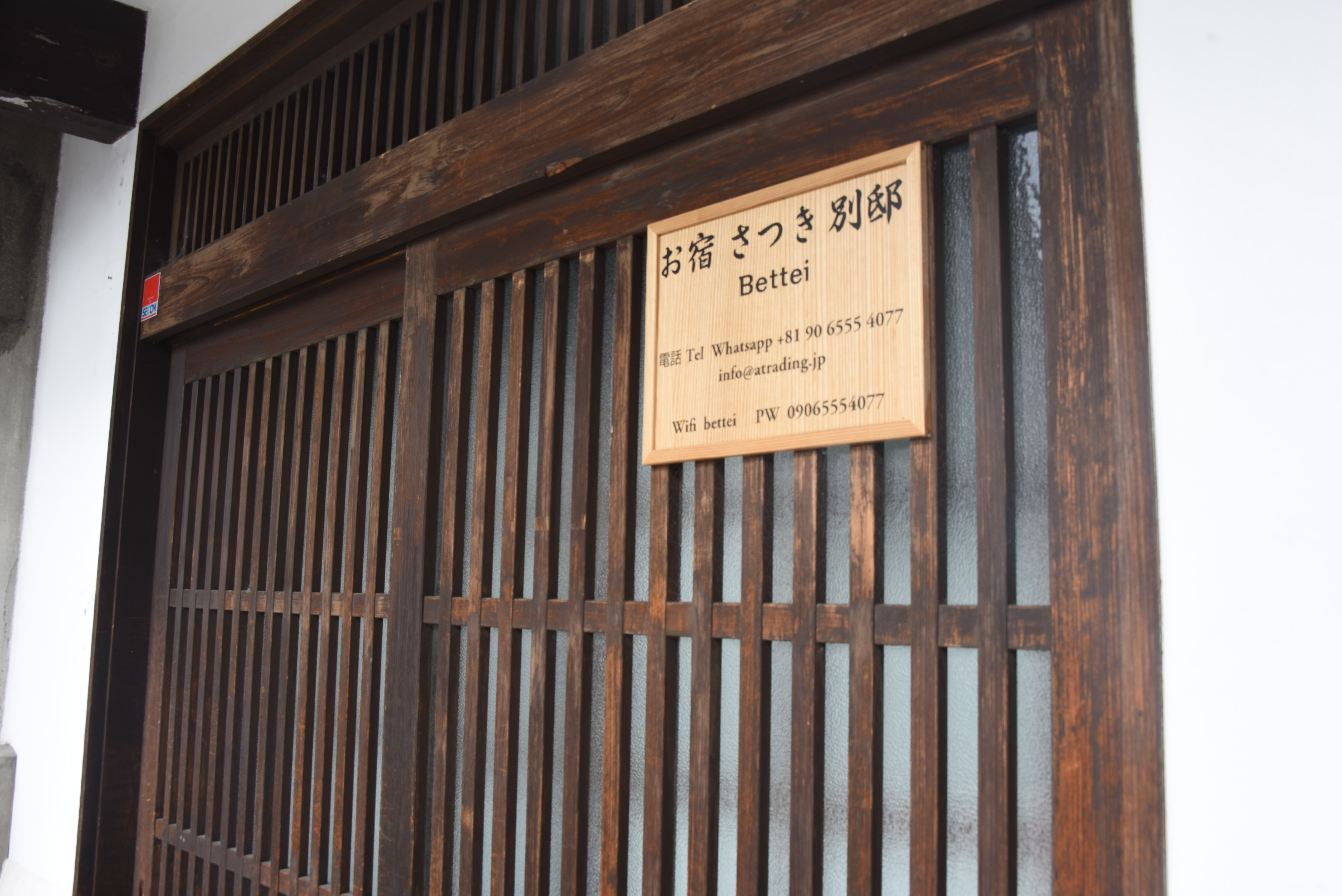 木の引き戸に掲げられた看板が、別邸の落ち着いた風情を静かに伝えてくれる。