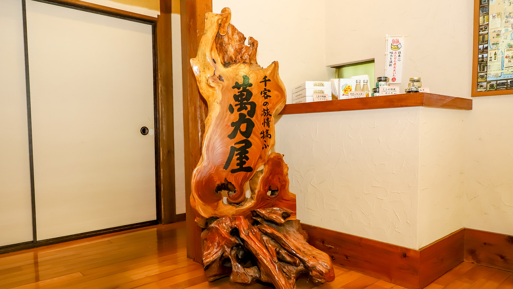 【施設備品】玄関に据えられた看板は萬力屋の象徴。看板の前で旅の思い出を一枚いかがですか