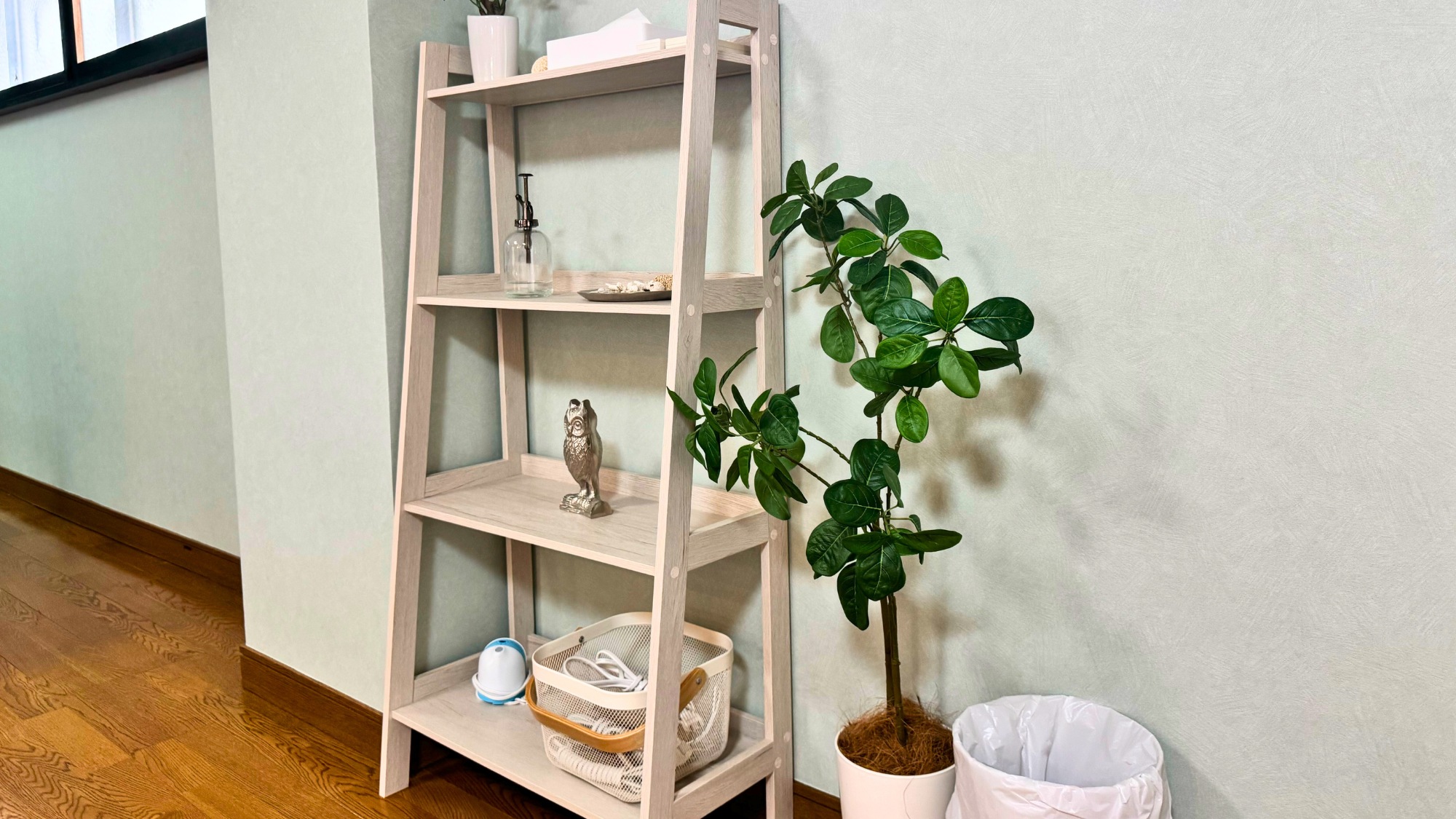 観葉植物が置かれた木製の棚がある廊下