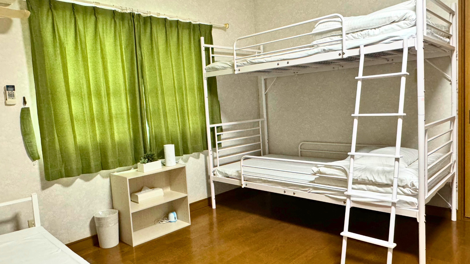 緑のカーテンが特徴の二段ベッドの寝室