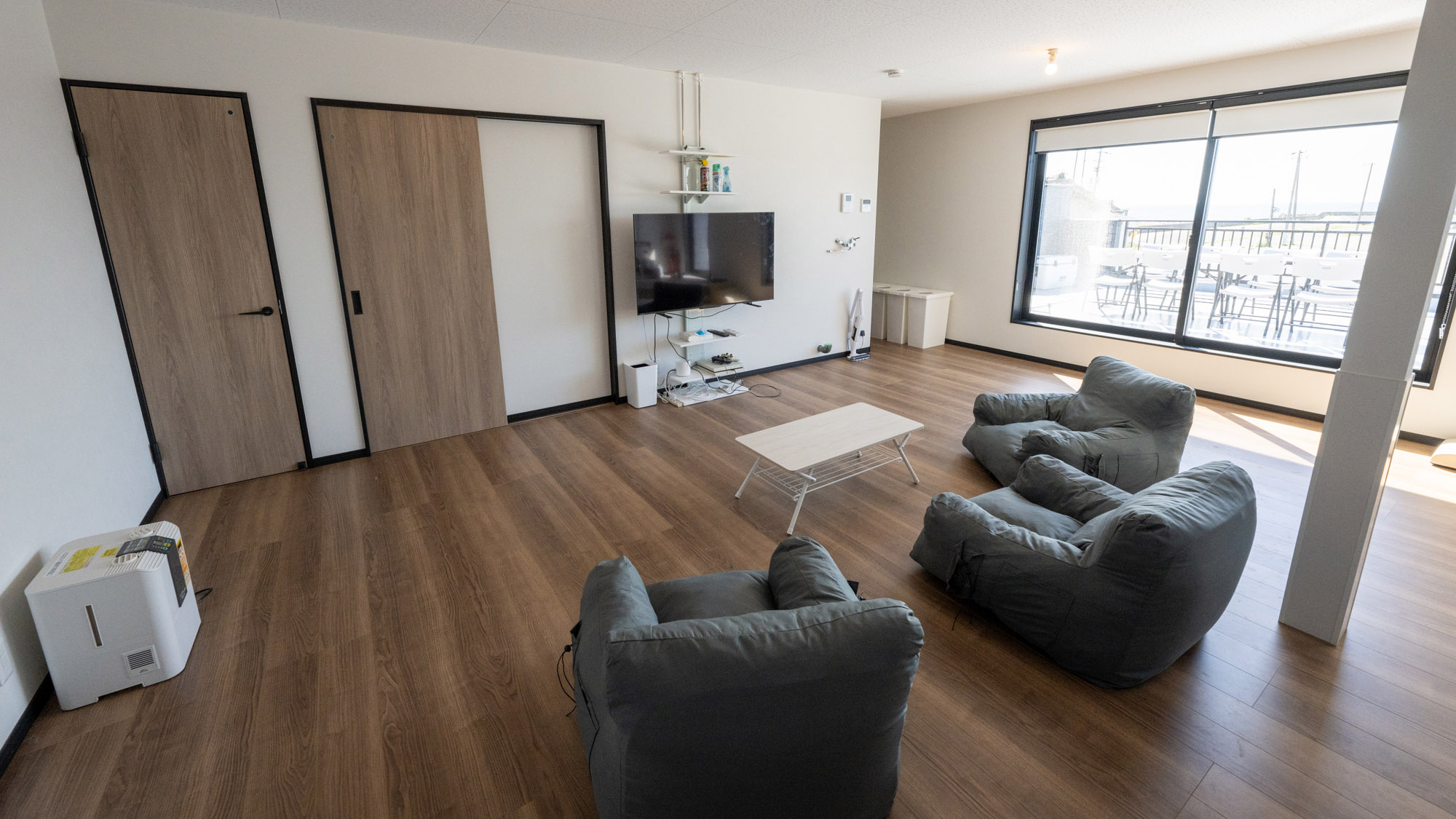 ・【2F/リビング】ふかふかソファでゆったり。大きな窓からバルコニーと美しい海をご覧いただけます