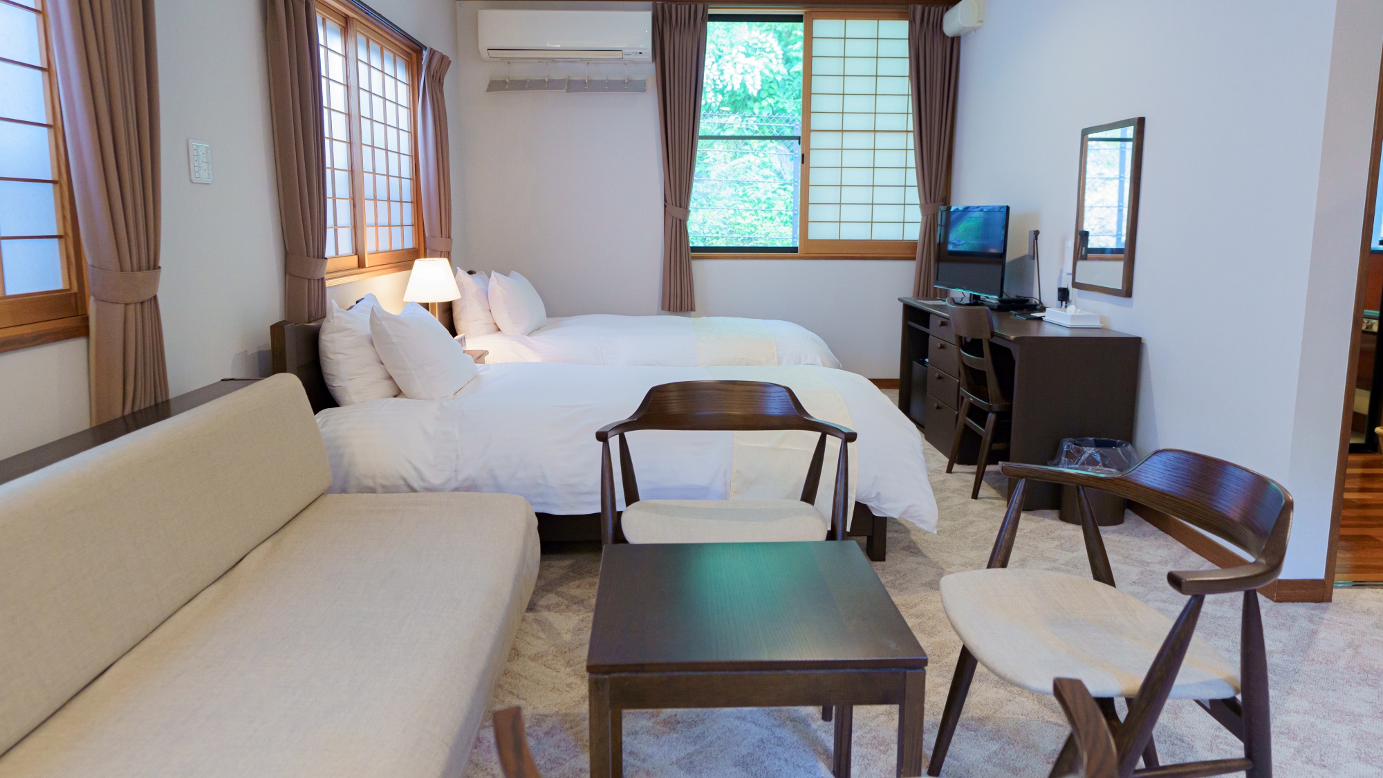【客室】デラックスツイン：ソファ、テーブル、ベッドがあるので室内でご自由にお過ごしいただけます。