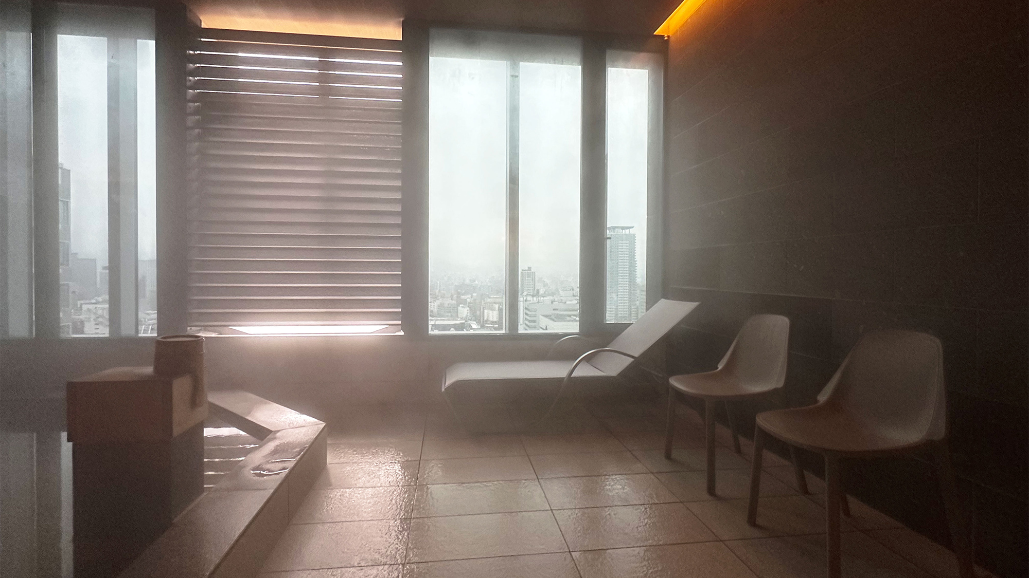 【スカイスパ】＜25F＞外気浴スペース／足を伸ばしてくつろげるローチェア1台、イス2台を配置