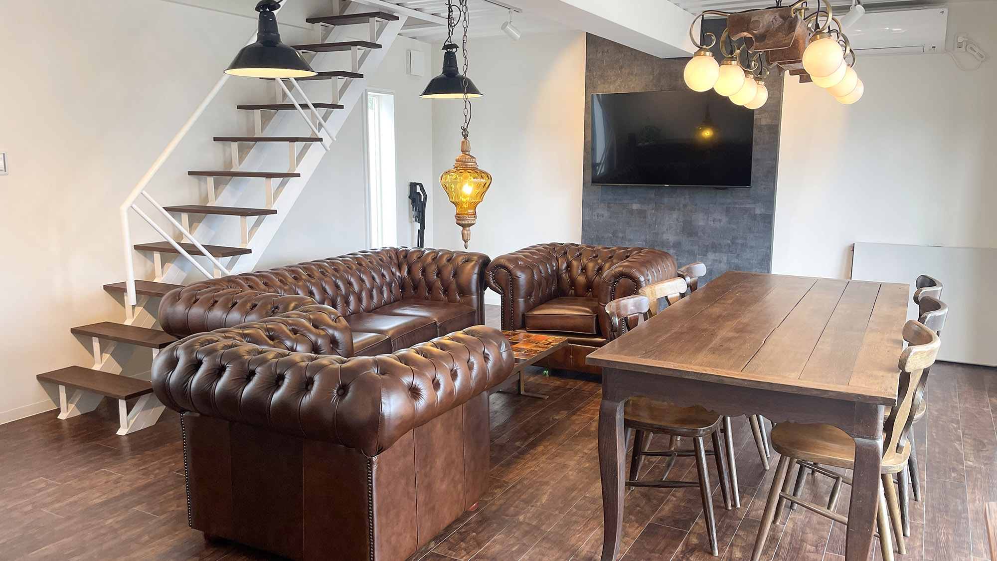 ・【A棟／リビング＆ダイニング】高級感のあるソファで大画面のテレビをお楽しみいただけます