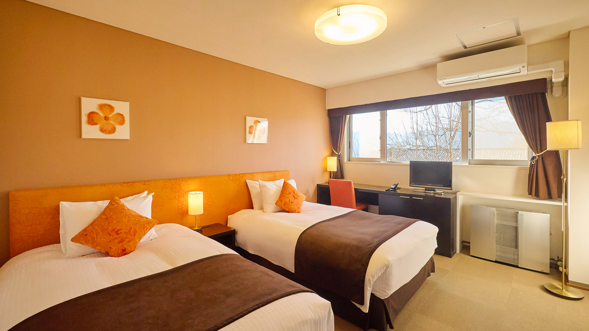 ・【客室一例】ベッドのほかに、テーブル、テレビを設置。窓の外には雄大な自然が広がります