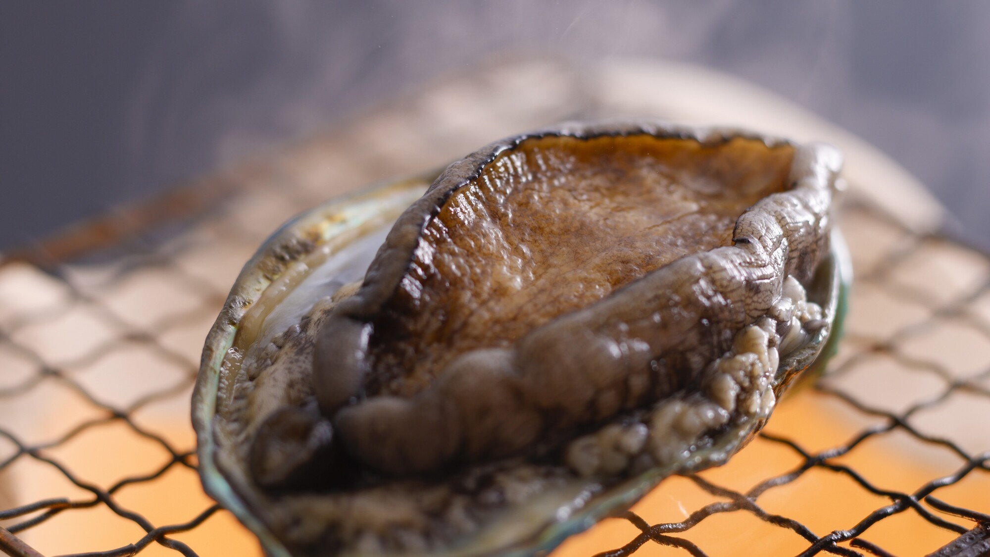 新鮮なアワビを豪快に焼き上げる、贅沢な踊り焼き／例