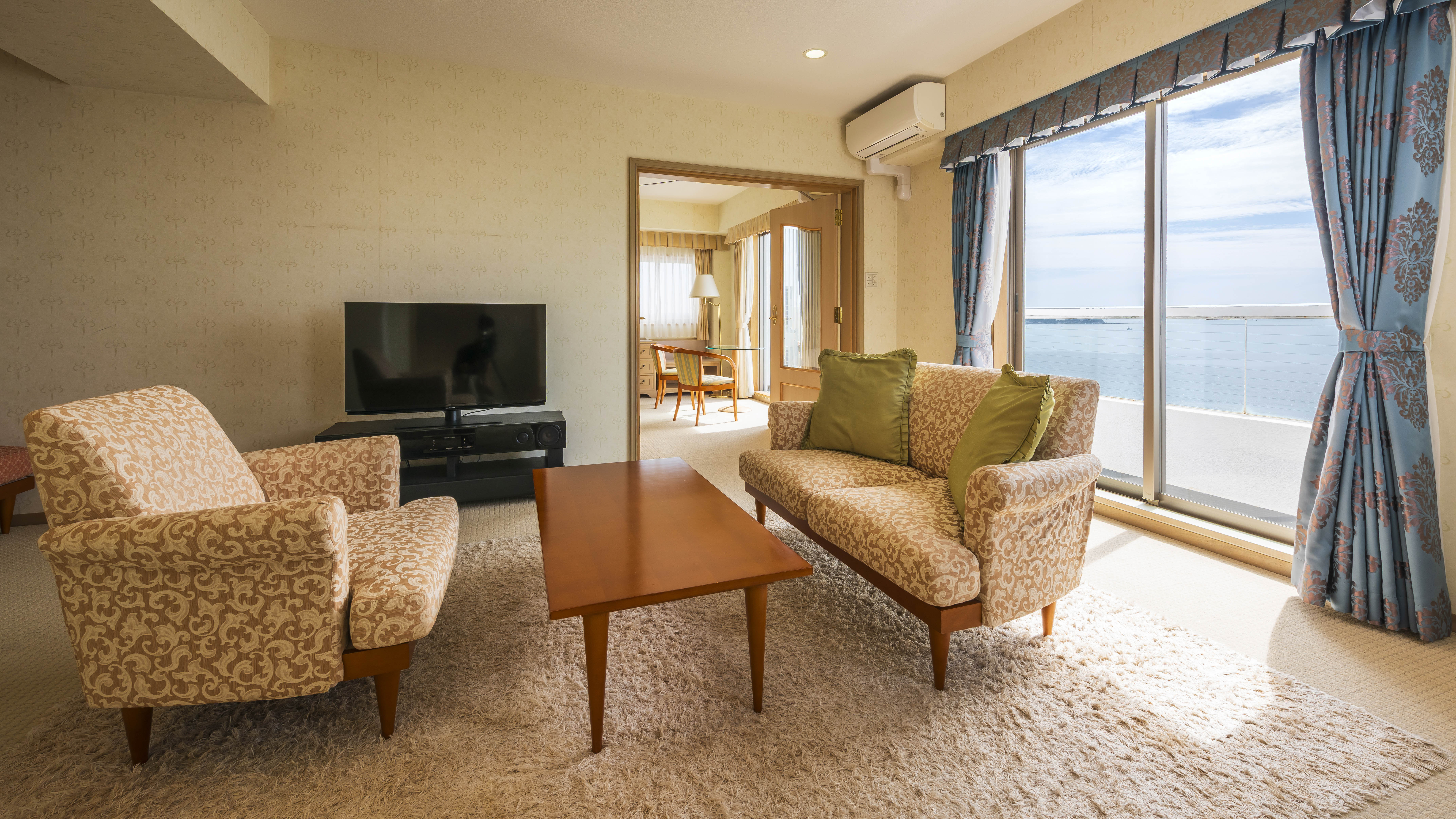 【スイートルーム】リビングとベッドルームがセパレートの広々空間。客室の窓からは相模湾一望。