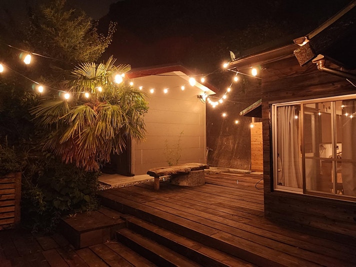 夜のウッドデッキです。ライトが点きますので、夜でもお楽しみいただけます。真ん中に木の台が見える...