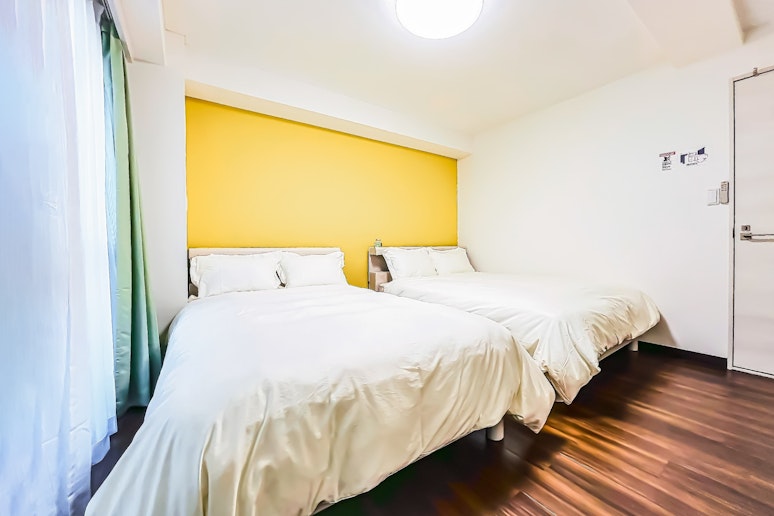 弥生旅館（YayoiHotel）の1階洋室の照明はリモコン式で消灯が可能。2台のダブルベッドの...