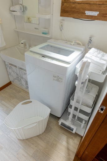洗濯機の横には、掃除機。折り畳み式の洗濯カゴもございますので御利用下さい。