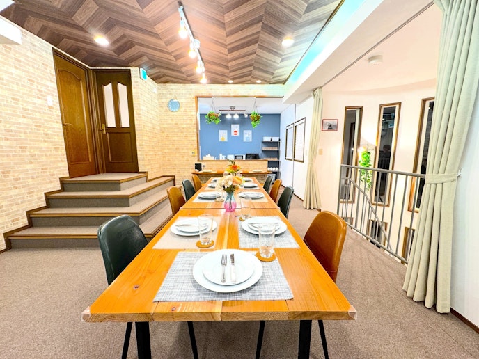 複数人での滞在にも対応した広々としたダイニングエリア。天井の間接照明と壁のデザインが空間にアク...